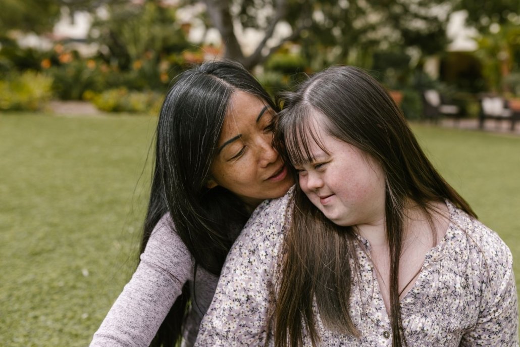Mãe abraçando a filha em um jardim