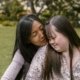 Mãe abraçando a filha em um jardim